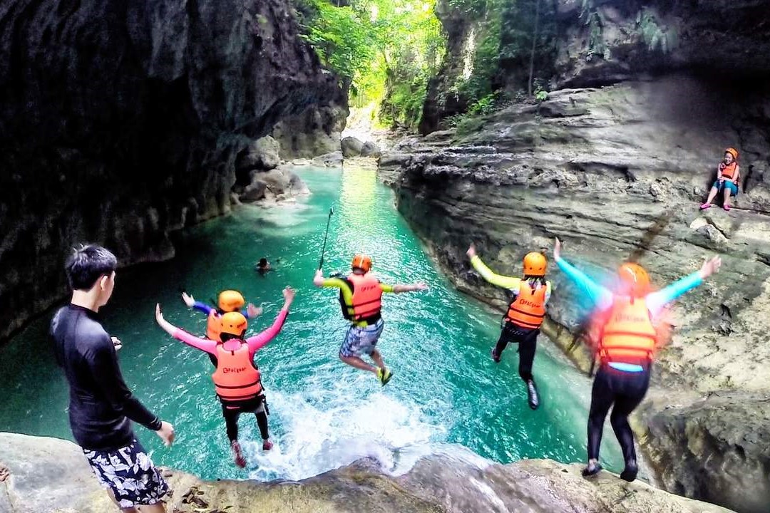 group of people jumping from kawasan falls