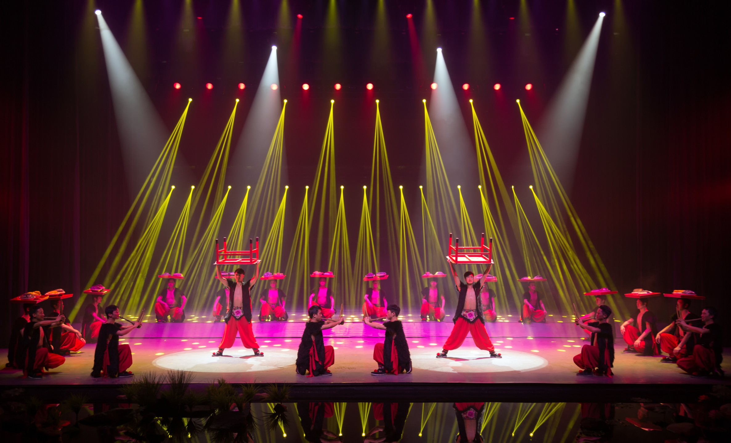 舞者們手持紅凳、斗笠，以對稱陣型排布，展現廣西民俗中 “板凳龍” 的靈動與菸火氣