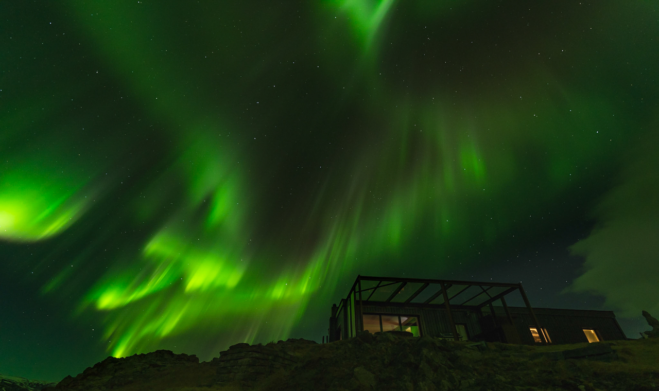 Witness the magical green glow of the Northern Lights dance across Iceland’s skies