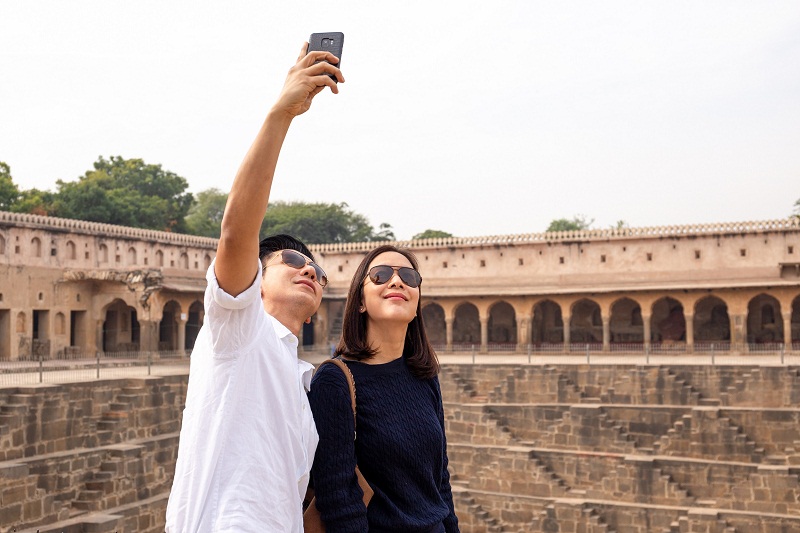 Asian couple happy in love taking selfie photo on Chand Baori Stepwell.