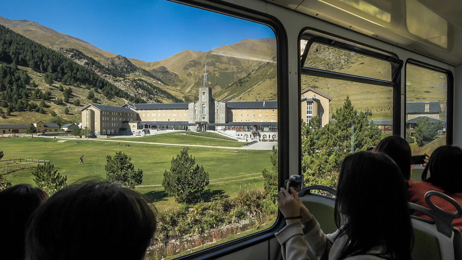 Admiring the stunning Vall de Nuria Sanctuary through the train window, surrounded by majestic mountains