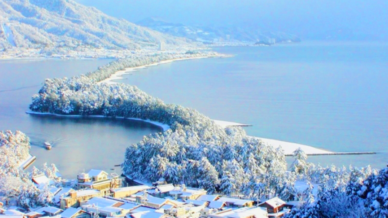 冬日降雪後，天橋立的白沙洲被積雪輕蓋，搭配岸邊常青的黑松，絕美