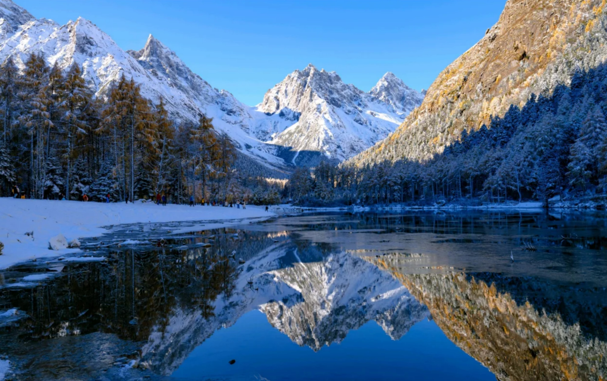 巍峨的雪山倒映在平靜如鏡的湖水中，形成完美的對稱畫面，展現了大自然的壯美與和諧