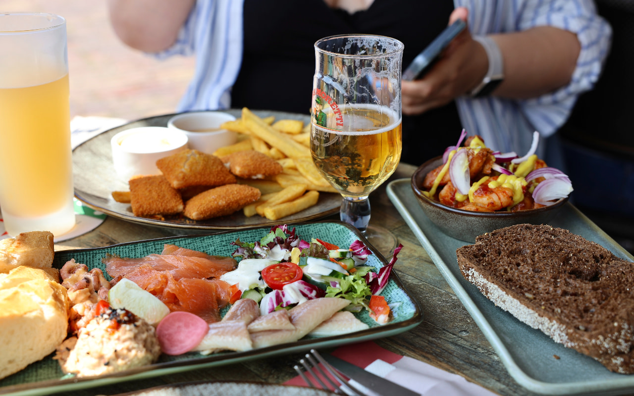 在沃倫丹堤防沿岸迷人的餐廳，盡享新鮮鯡魚和當地海鮮特色美食。