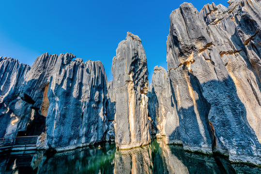 碧水如鏡，倒映石峰，將雄奇石林與柔美水景融合，寧靜秀麗