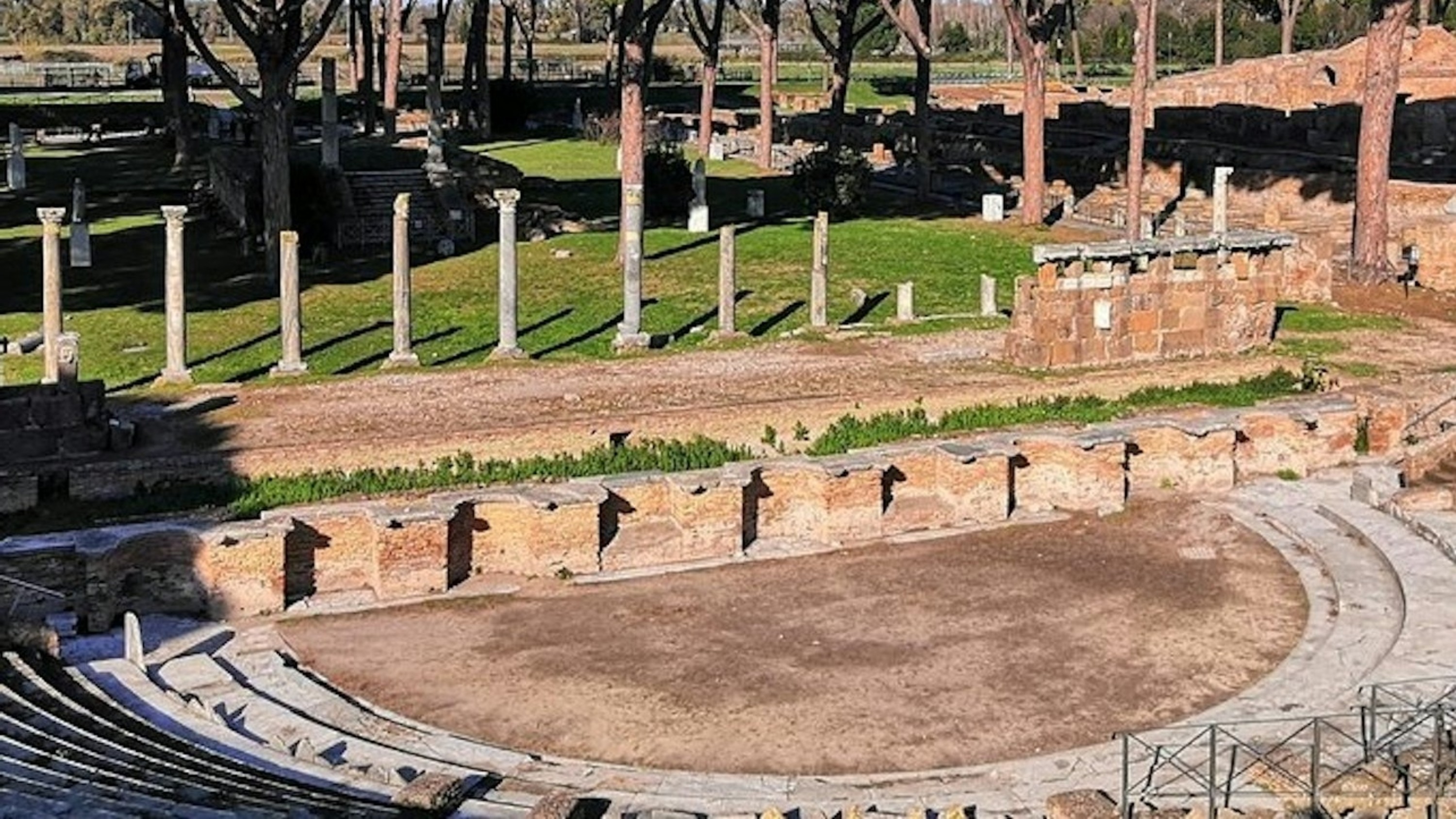Roman theatre with semi-circular stone seating, once hosting thousands of lively spectators