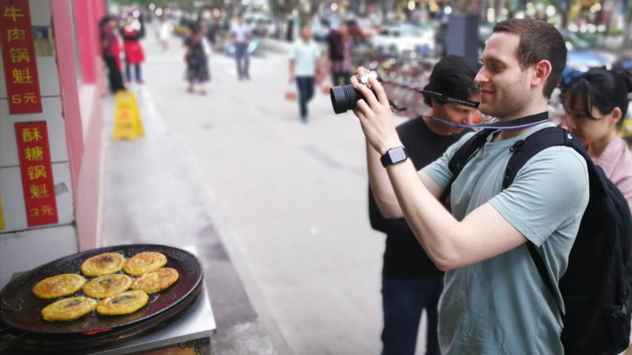 a guy taking picture of chengdu food