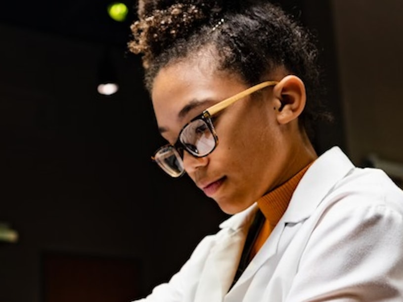 Student in lab coat working carefully, embodying the spirit of future science innovation