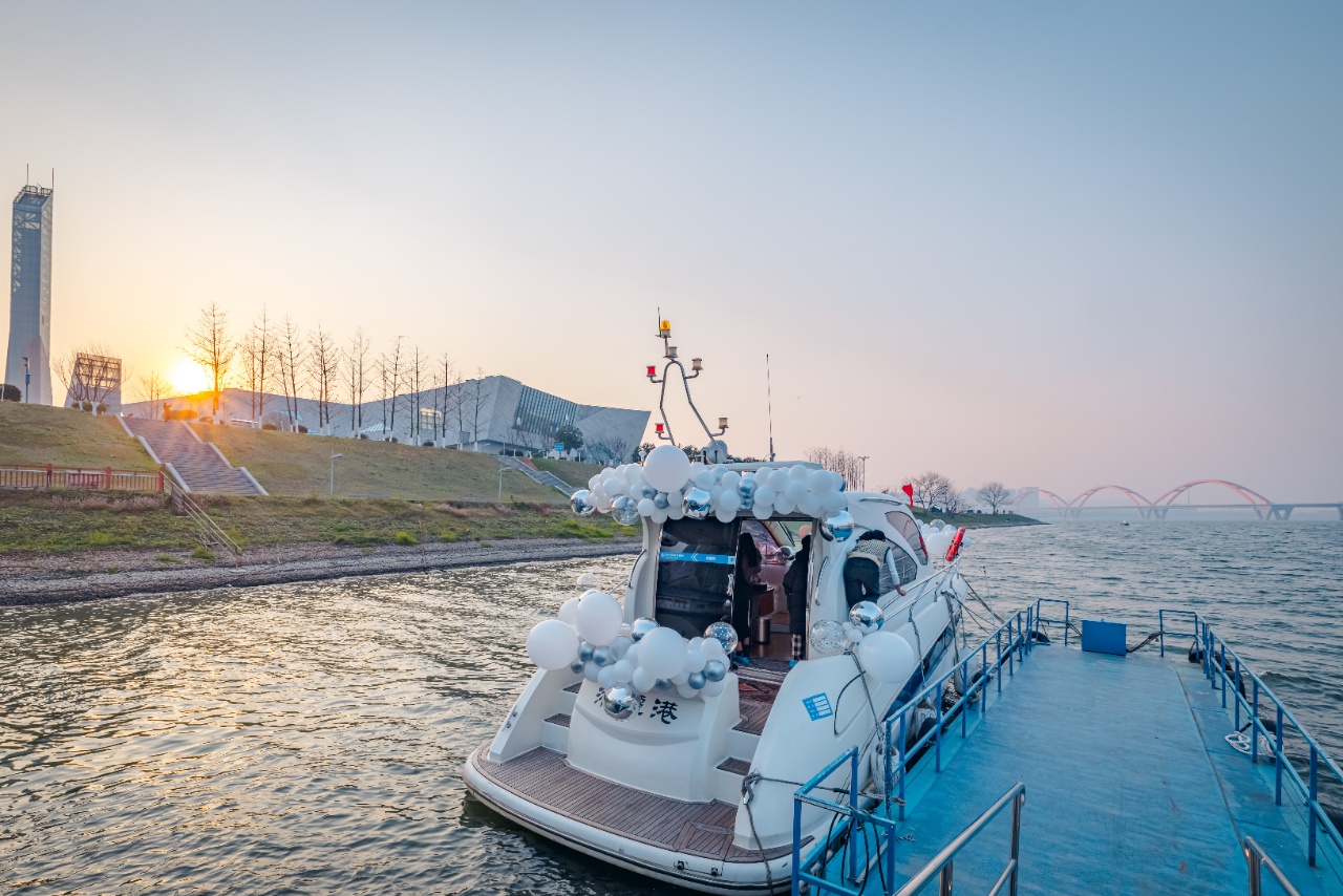 The setting sun painted the sky with soft shades of pink and orange, while the silhouettes of the pagoda and buildings along the shore were edged with gold in the backlight.