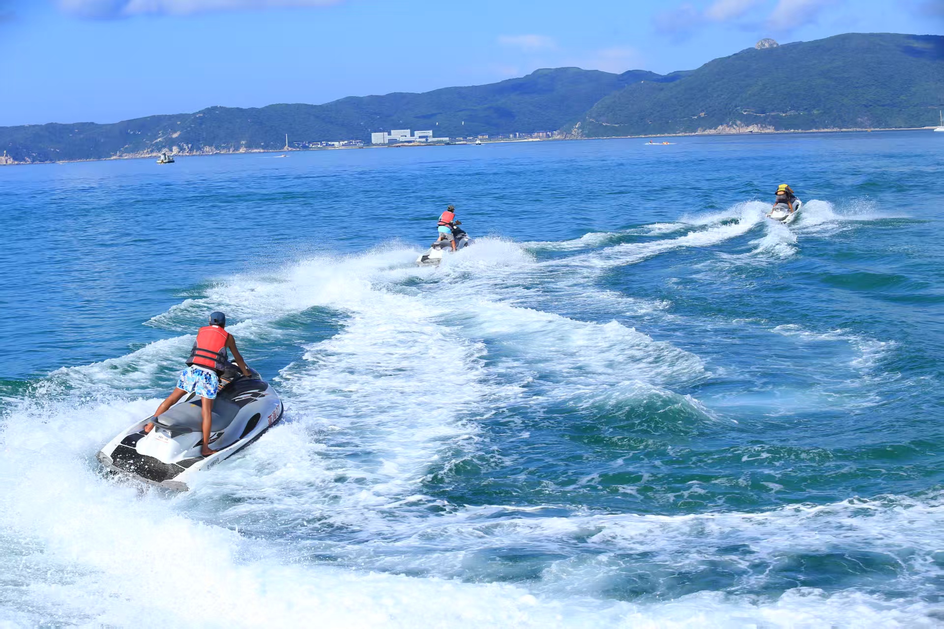 摩托艇:幾人駕駛摩托艇在湛藍海面疾馳,激起白色浪花,背景是青山與遠岸建築,盡顯海上運動的刺激與海濱風光的美好 摩托艇:幾人駕駛摩托艇在湛藍海面疾馳,激起白色浪花,背景是青山與遠岸建築,盡顯海上運動的刺激與海濱風光的美好