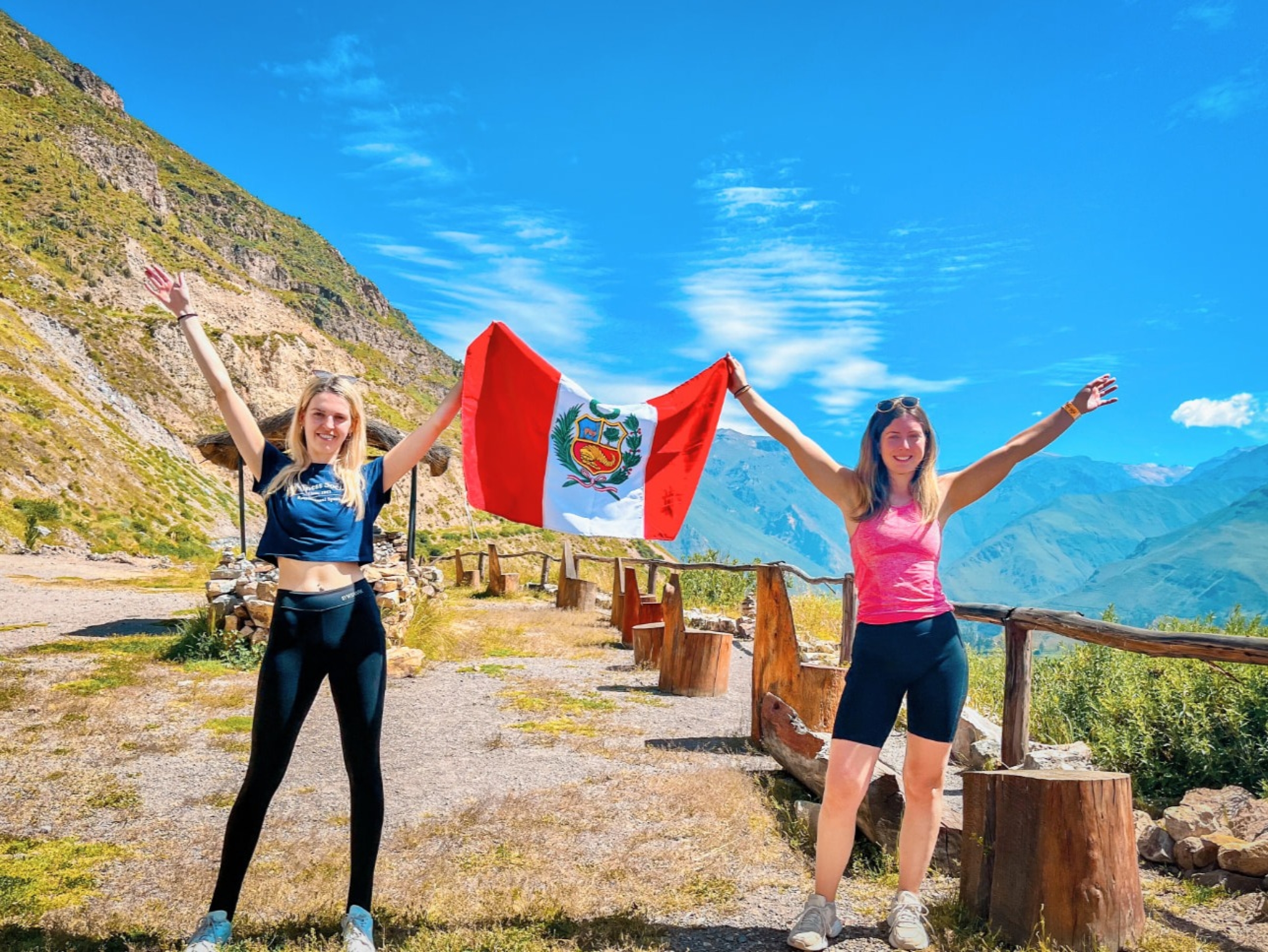 Hikers celebrating with the Peruvian flags and stunning mountain views