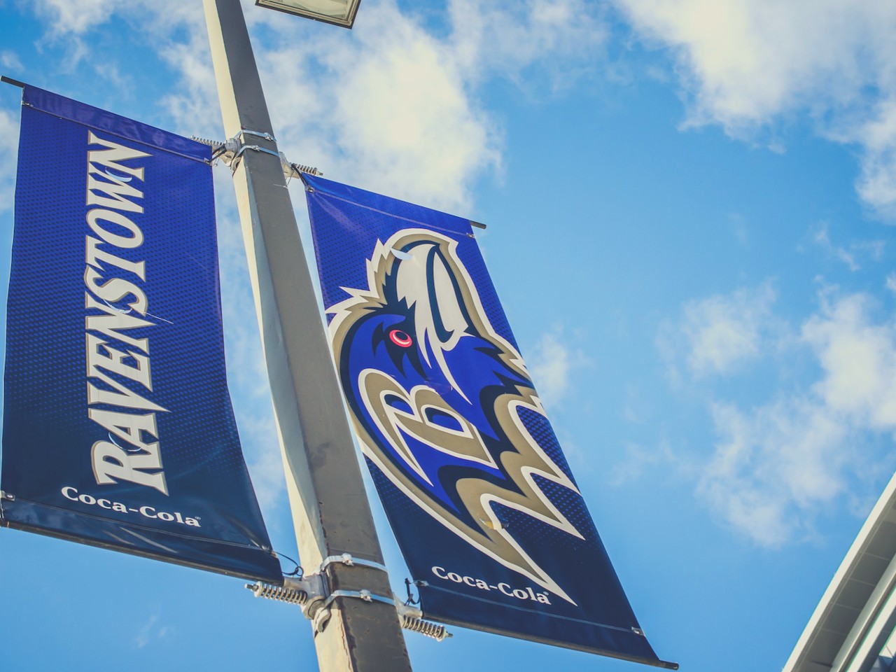Massive Ravens flag soar high, showcasing team pride across the vibrant stadium skyline