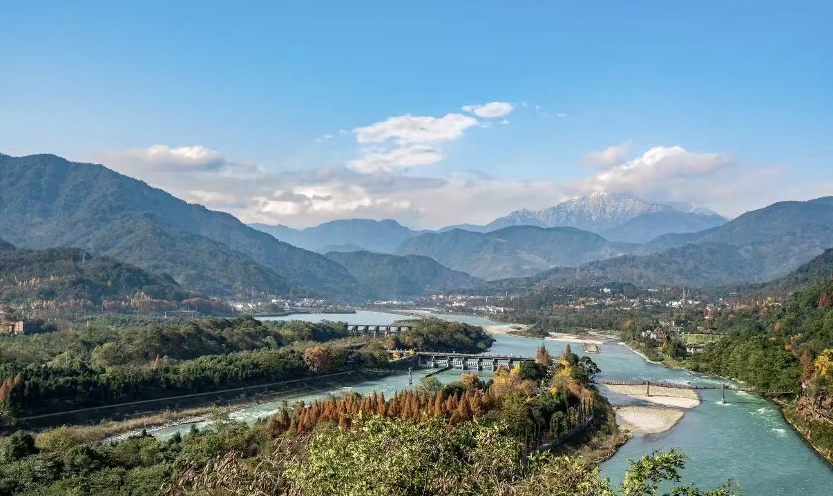 遠眺都江堰水利工程,岷江在此分流,遠山連綿,偶見雪山覆頂,江水如碧帶穿林而過,秋林色彩斑斕,盡顯工程與自然的和諧之美 遠眺都江堰水利工程,岷江在此分流,遠山連綿,偶見雪山覆頂,江水如碧帶穿林而過,秋林色彩斑斕,盡顯工程與自然的和諧之美
