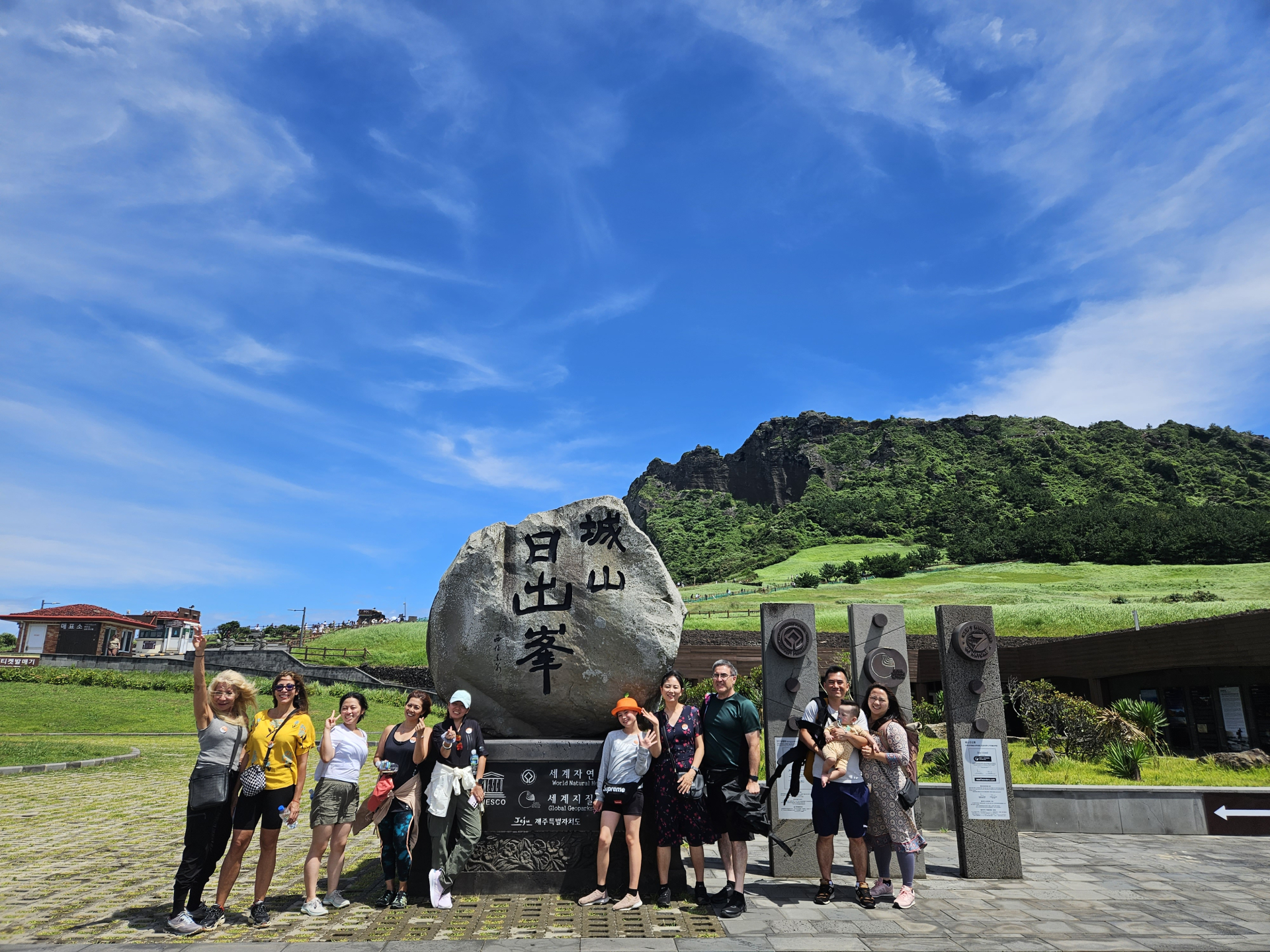 一群開心的旅客在標誌性的城山日出峰前合影。