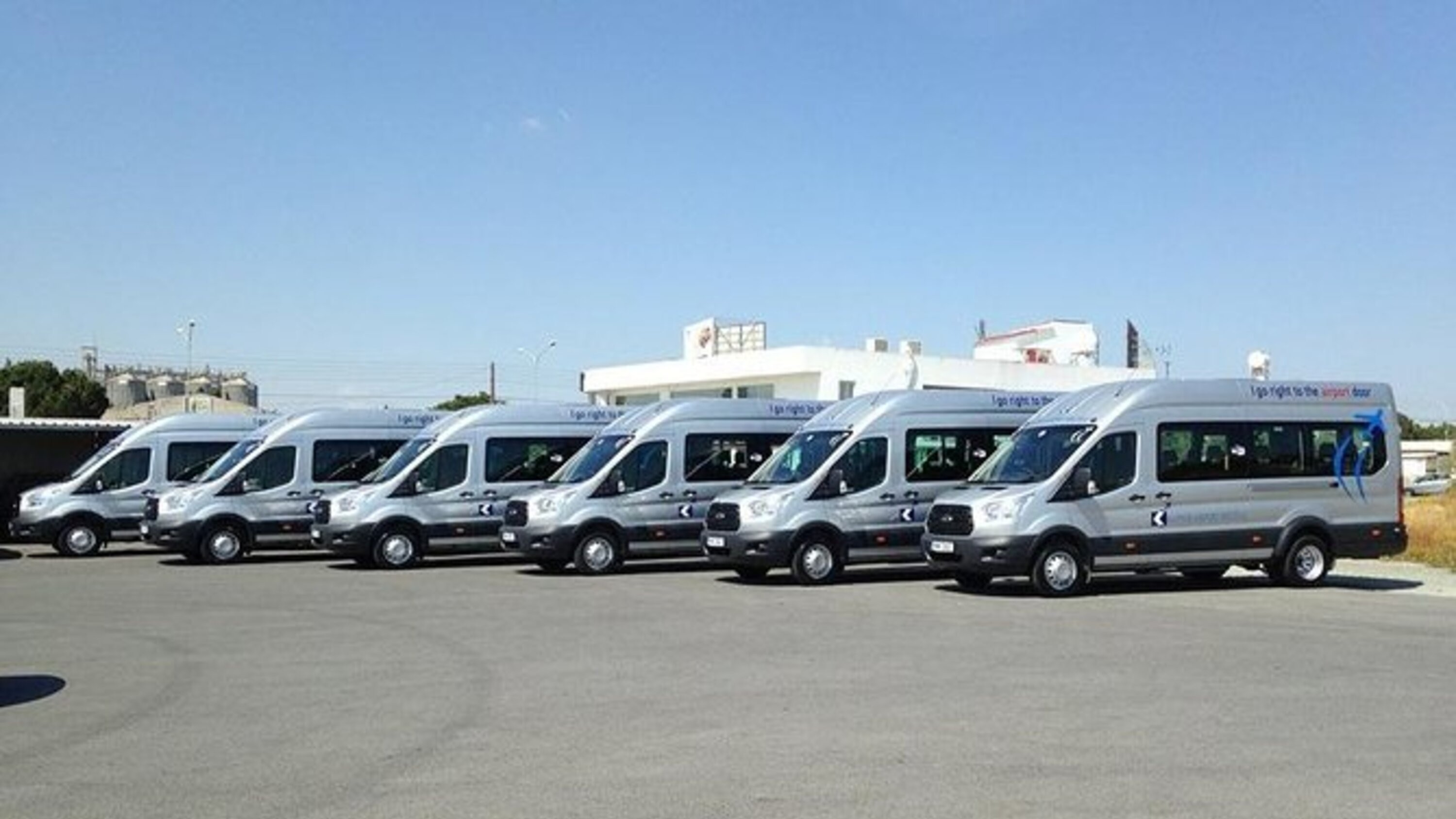 Shuttle buses lined up at the terminal, engines on and ready for departure