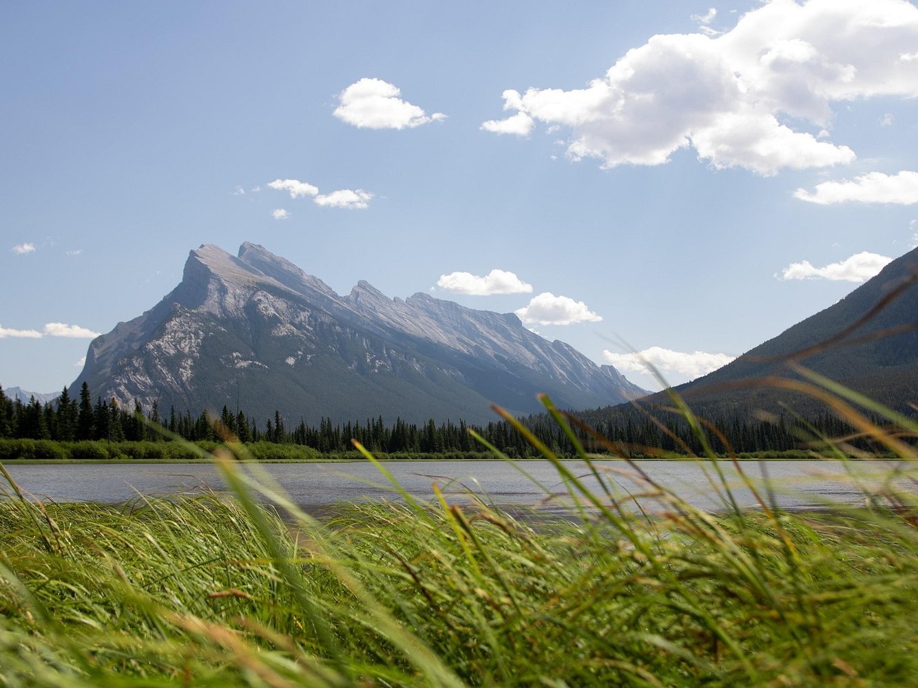 Gaze at Mount Rundle’s dramatic silhouette rising sharply against Banff’s winter sky