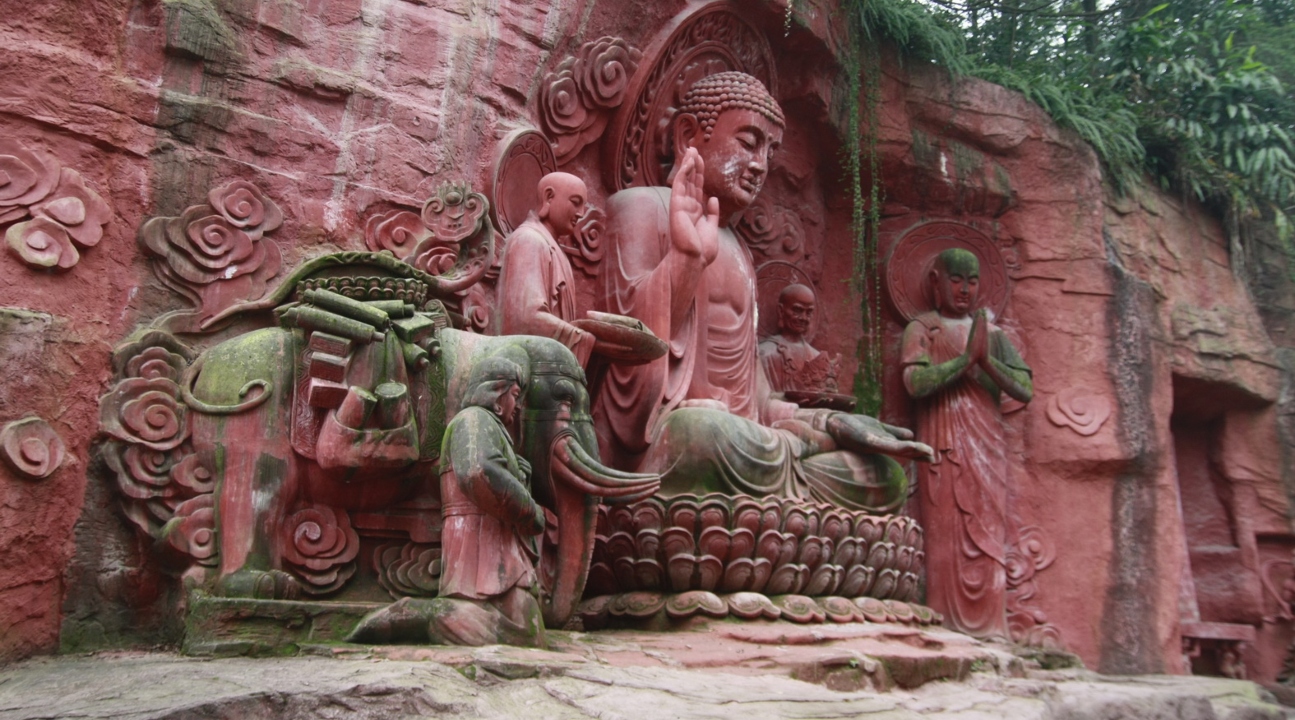 a Buddhist statue with a red and pinkish tint