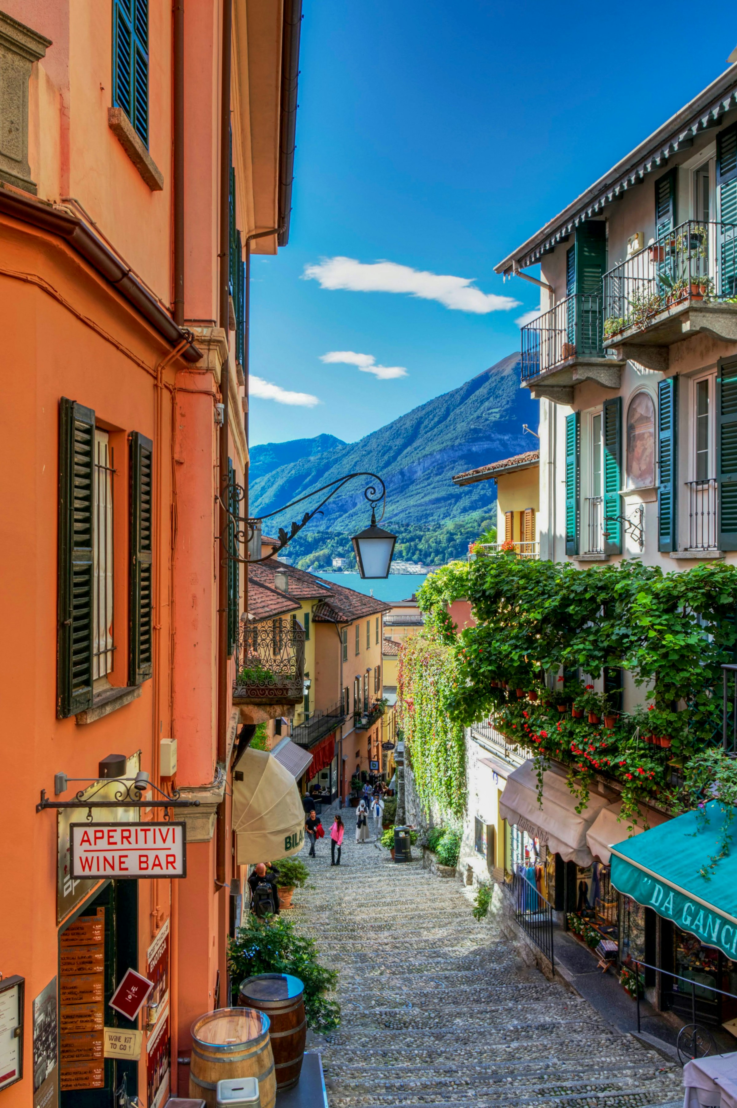 A steep, winding cobblestone street descends through the charming village of Bellagio on Lake Como, Italy