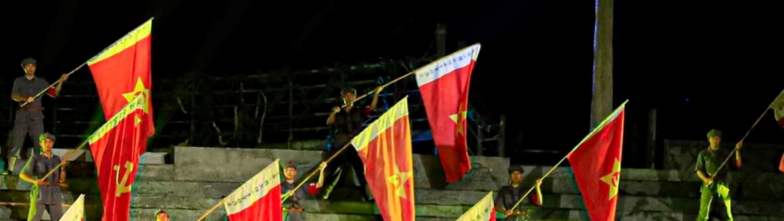 草帽綴標語、紅旗列陣，演員昂揚造勢，彰娘子軍的信仰與團結