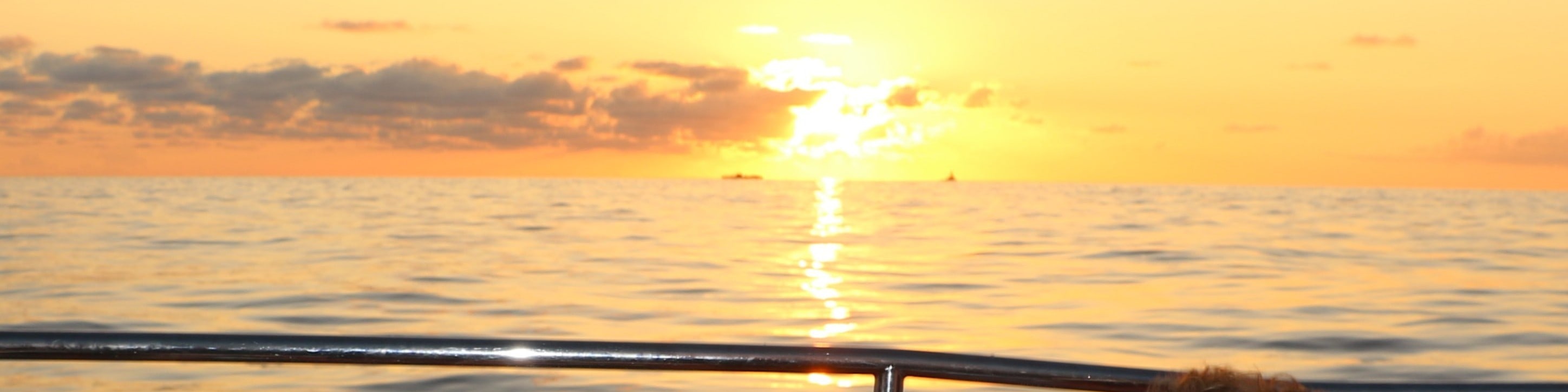 Guests often gather on the open deck to capture stunning photos of Oahu’s colorful sunset