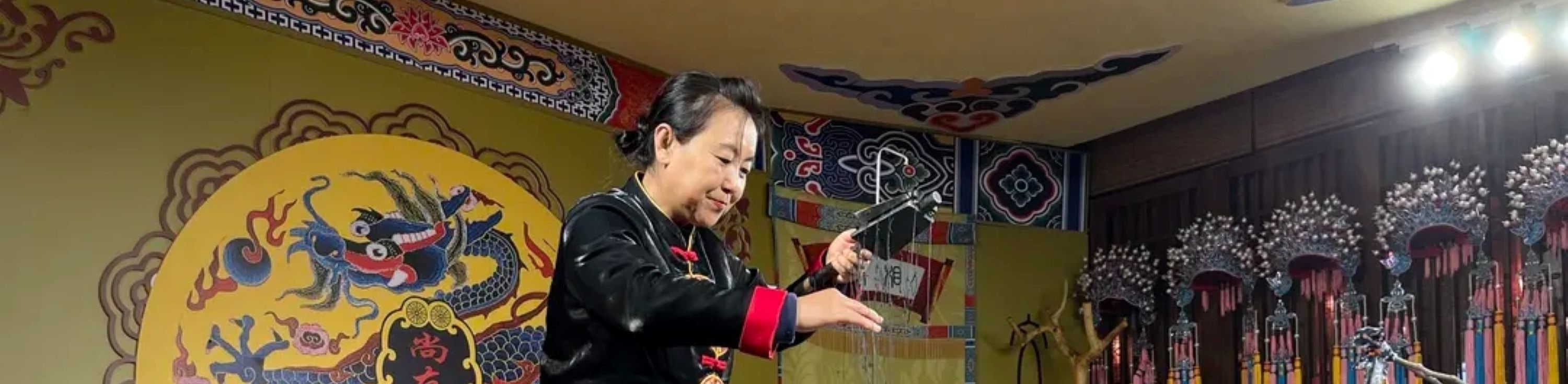 表演者操縱木偶,木偶身著藍色戲服,造型精緻,呈現出木偶戲的表演形式,體現了陝西非遺戲曲中木偶戲的獨特技藝與文化傳承 表演者操縱木偶,木偶身著藍色戲服,造型精緻,呈現出木偶戲的表演形式,體現了陝西非遺戲曲中木偶戲的獨特技藝與文化傳承