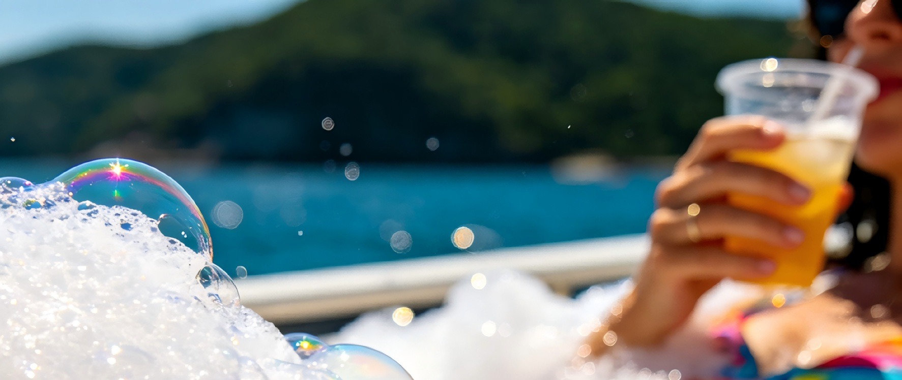 A close-up shot of a Fethiye bubble boat party, with crystal-clear bubbles enveloping ice drinks in tourists' hands, and iridescent bubbles refracting the sunlight, creating a full sense of summer relaxation.