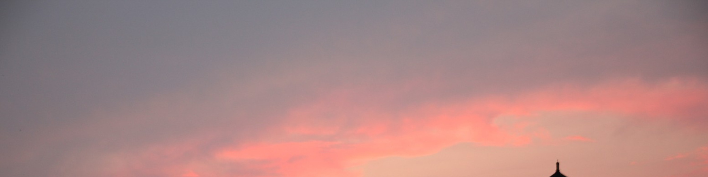 Admire Chicago Harbor Lighthouse glowing beautifully against the colorful evening sunset skies