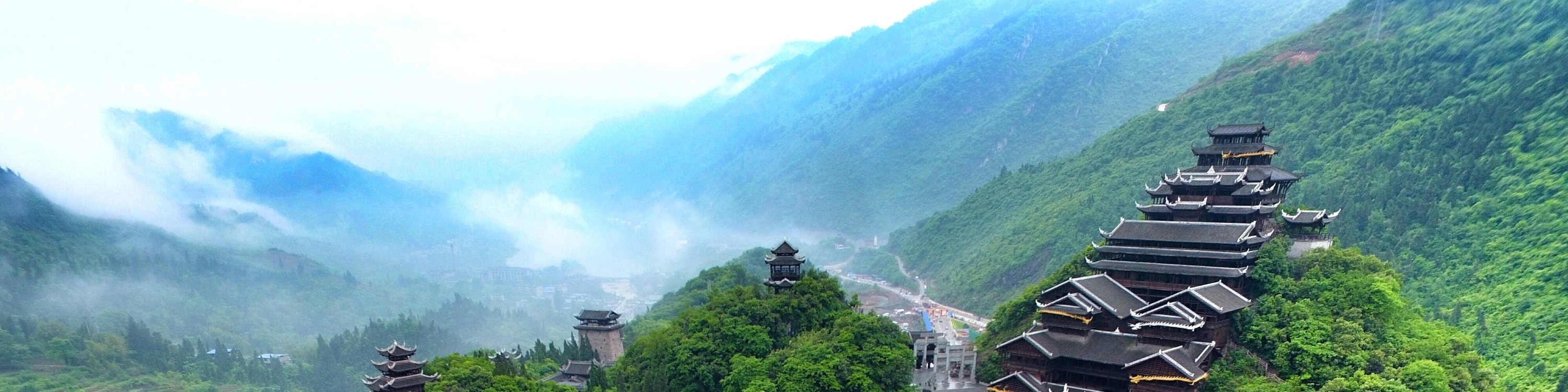蚩尤九黎城日間全景，九層苗族吊腳塔樓依山而建，飛簷層疊，氣勢雄渾古樸。