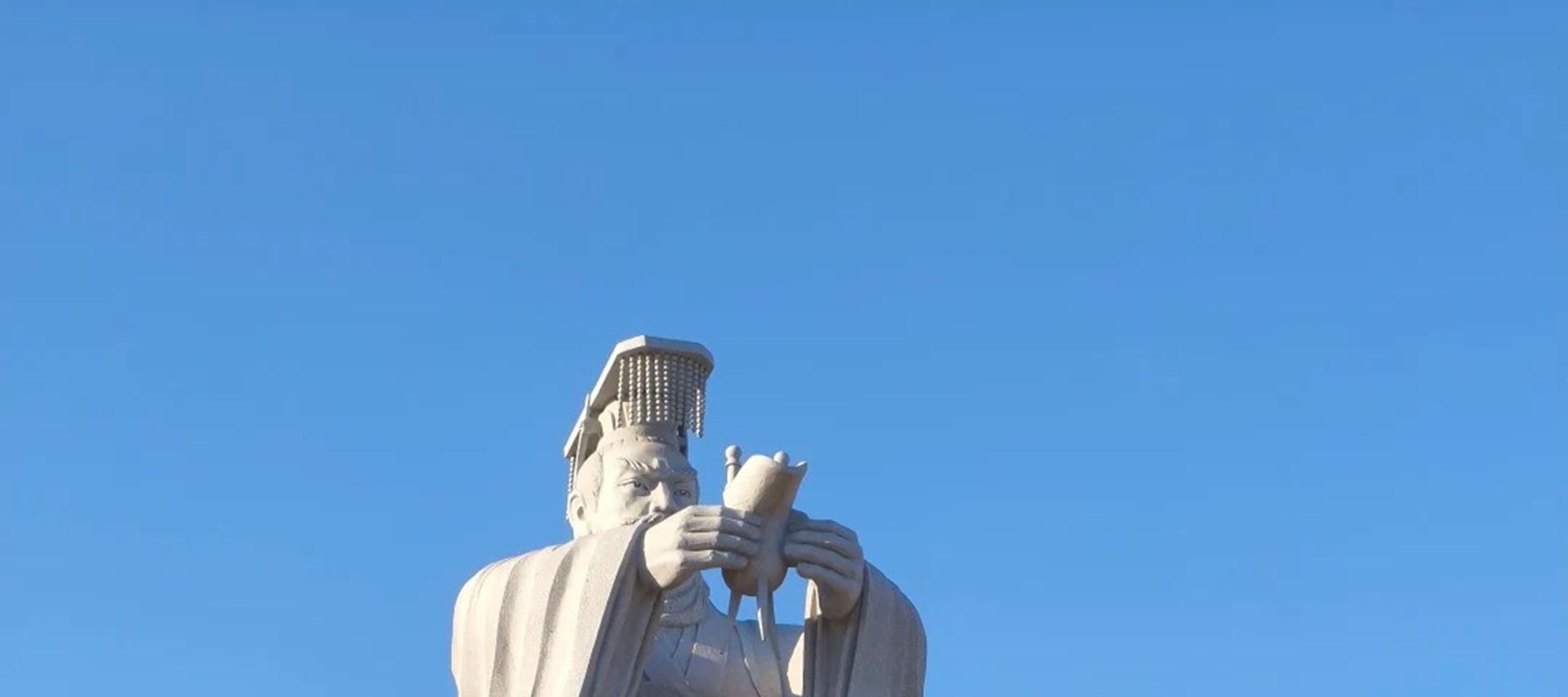 冕旒長袍執簡凝望滄海,漢白玉基座祈福紅綢垂綴,古柏碧空映襯帝王求仙傳說,歷史煙雲與今人祈願在此交響 冕旒長袍執簡凝望滄海,漢白玉基座祈福紅綢垂綴,古柏碧空映襯帝王求仙傳說,歷史煙雲與今人祈願在此交響
