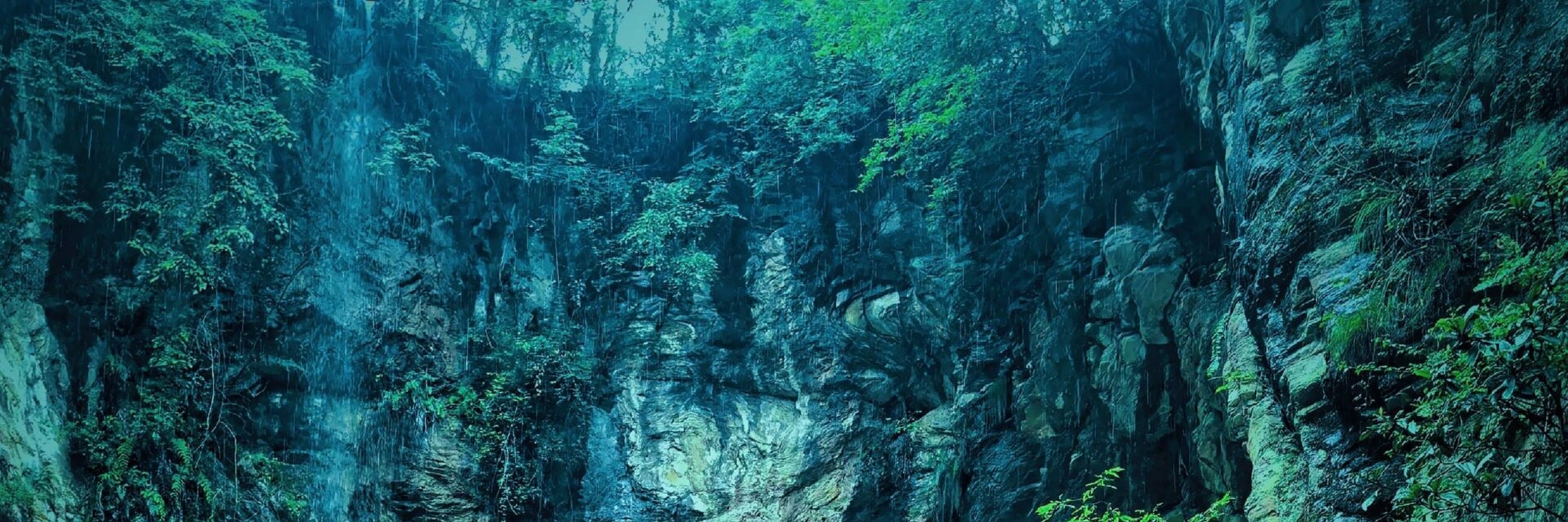 青綠色的潭水像一塊被山澗精心浸潤的翡翠，巖壁上垂落的細瀑帶著細碎的水汽，四周濃綠的植被把整片天地都暈染成了治癒的深色調。小小的皮筏在水面上漂流，彷彿闖入了與世隔絕的秘境，清冷又充滿野趣，隔著螢幕都能感受到峽谷裡撲面而來的清涼與自由