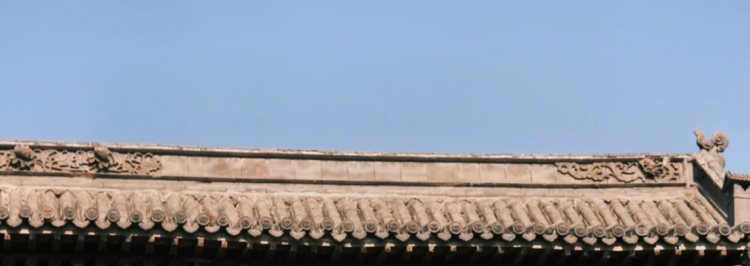 古建屋簷下紅燈籠高掛，雕樑畫棟細節精緻，紅灰色調交織，盡顯中式古建築的典雅韻味與傳統風情