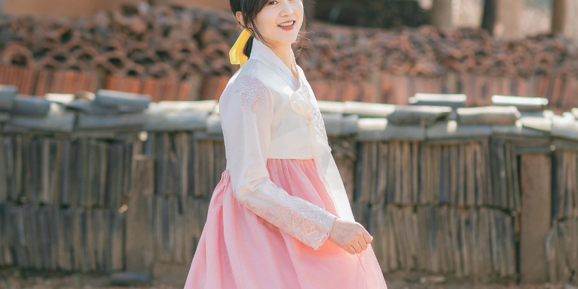 The hanbok’s vibrant colors blend perfectly with the spring scenery.