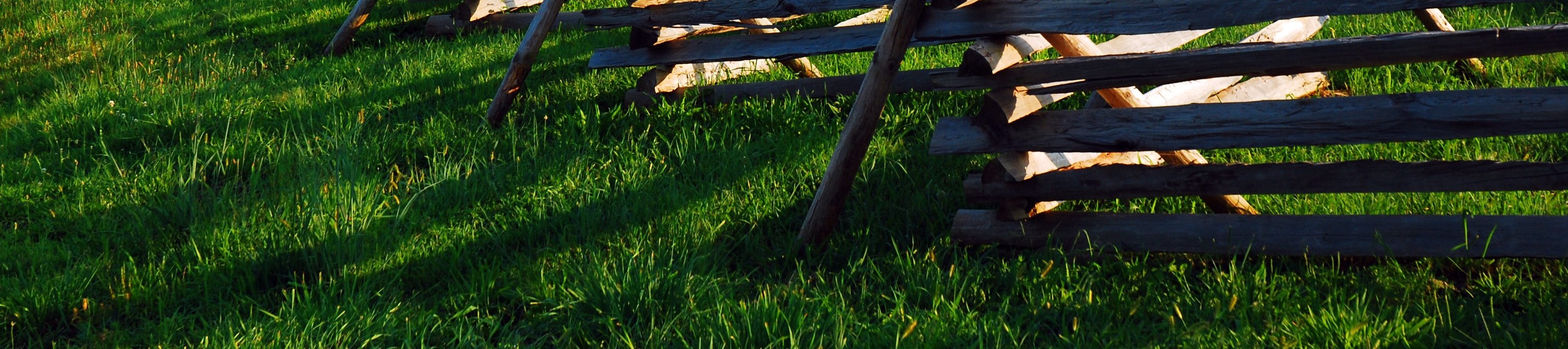 Observe a wood split rail fence cutting through a field at Gettysburg National Battlefield