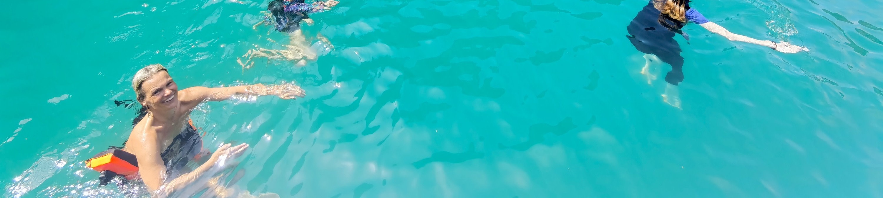 在溫暖的碧綠海水中暢遊,周圍環繞著巨大的石灰岩懸崖。 在溫暖的碧綠海水中暢遊,周圍環繞著巨大的石灰岩懸崖。