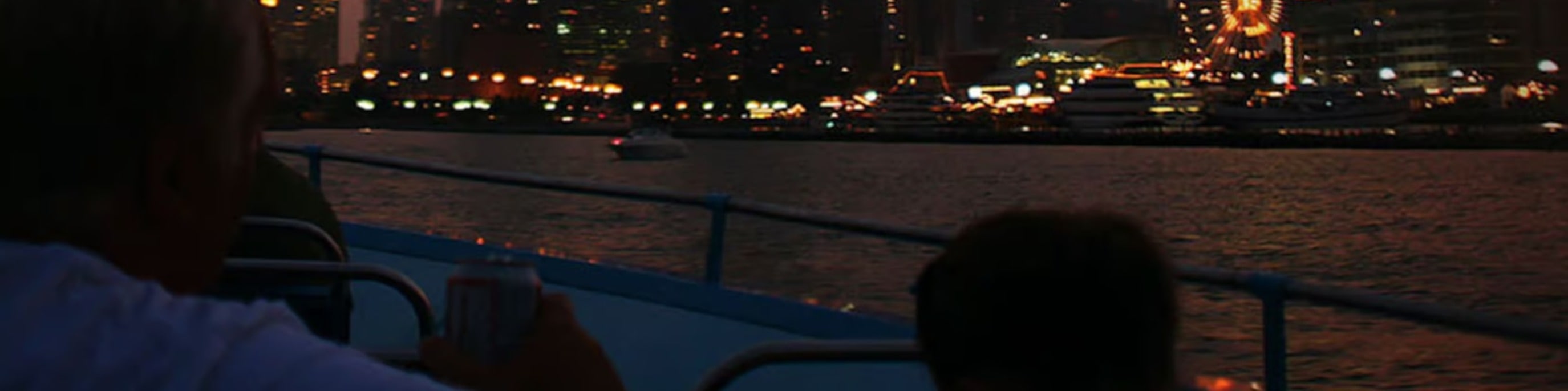 Vibrant evening lights shimmering across Lake Michigan waters during peaceful sightseeing cruise experience