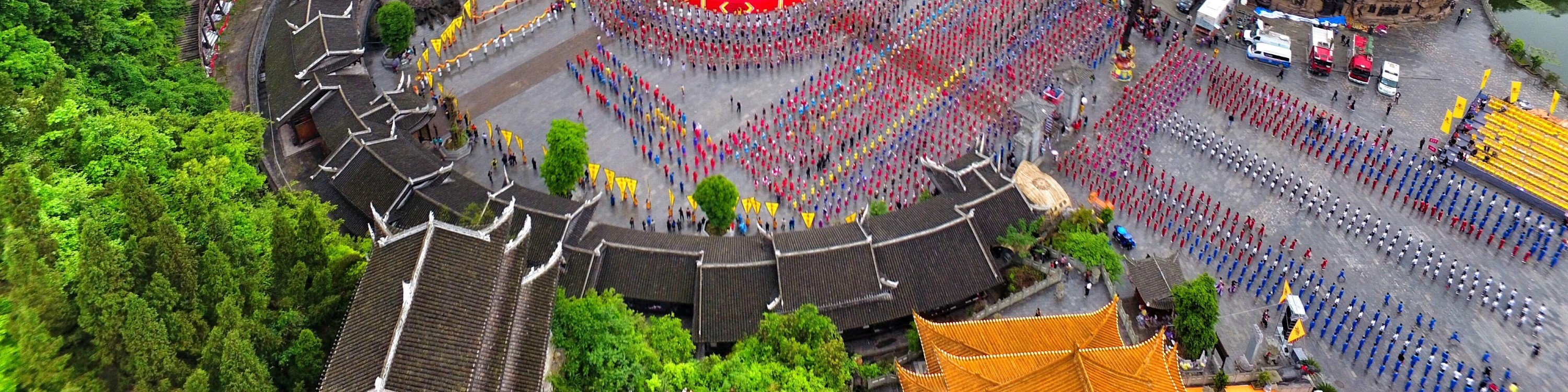蚩尤九黎城日間全景，九層苗族吊腳塔樓依山而建，飛簷層疊，氣勢雄渾古樸。