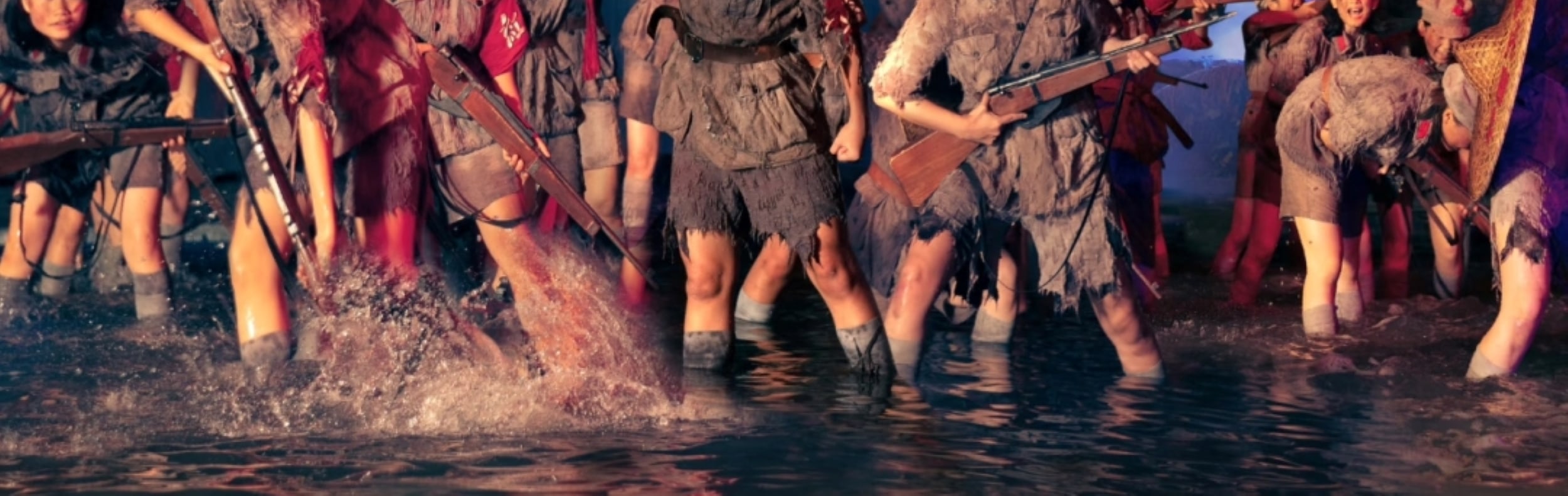 戰火舞臺 + 水花實景，演員持槍吶喊，重現娘子軍浴血奮戰的震撼場面