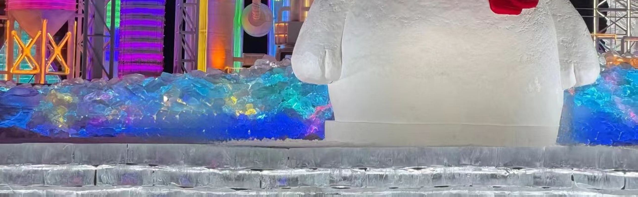 憨態可掬的雪人立於冰雕群前,紅圍巾紅帽子添了暖意,背景是七彩冰塔,冷色調裡藏著可愛,成了園區人氣打卡點 憨態可掬的雪人立於冰雕群前,紅圍巾紅帽子添了暖意,背景是七彩冰塔,冷色調裡藏著可愛,成了園區人氣打卡點