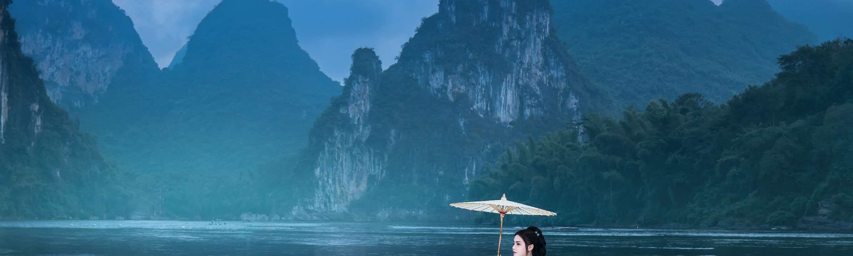 Green mist winds around the mountains, and the clear water is like a mirror. Cormorants stand still, and fishing lights glow faintly.