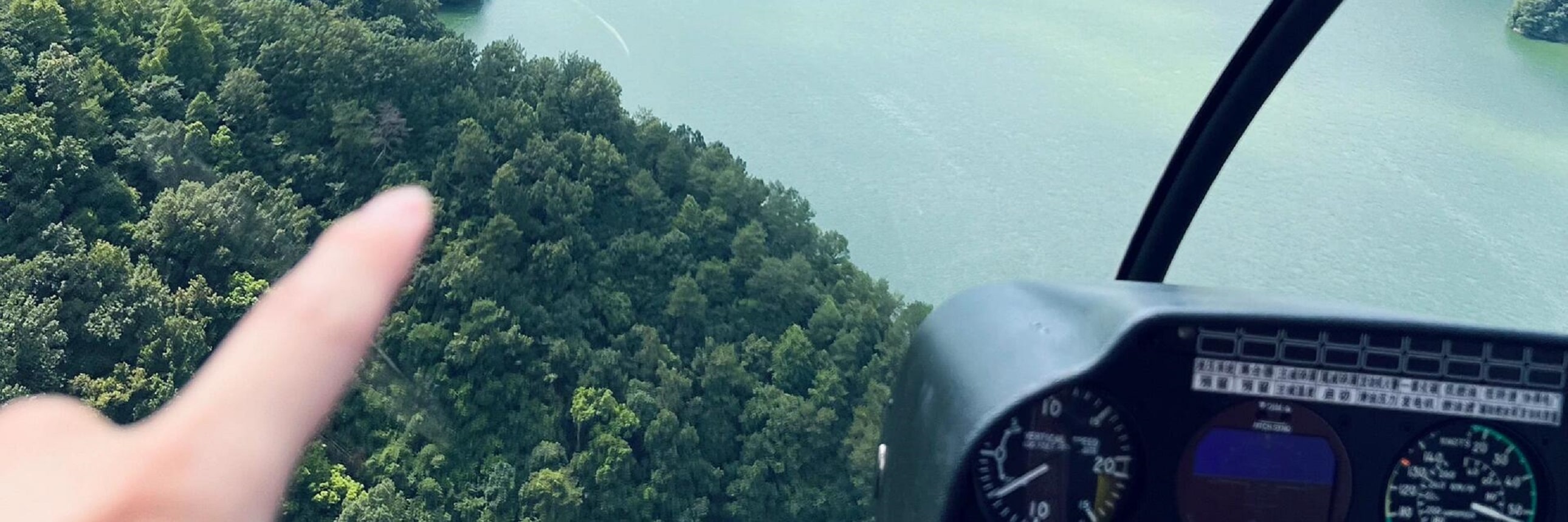 駕駛艙內，指尖輕指窗外千島湖山，澄澈湖水環繞青山，高空視角下的山水肌理清晰可見，沉浸式解鎖高空視野的治癒與震撼