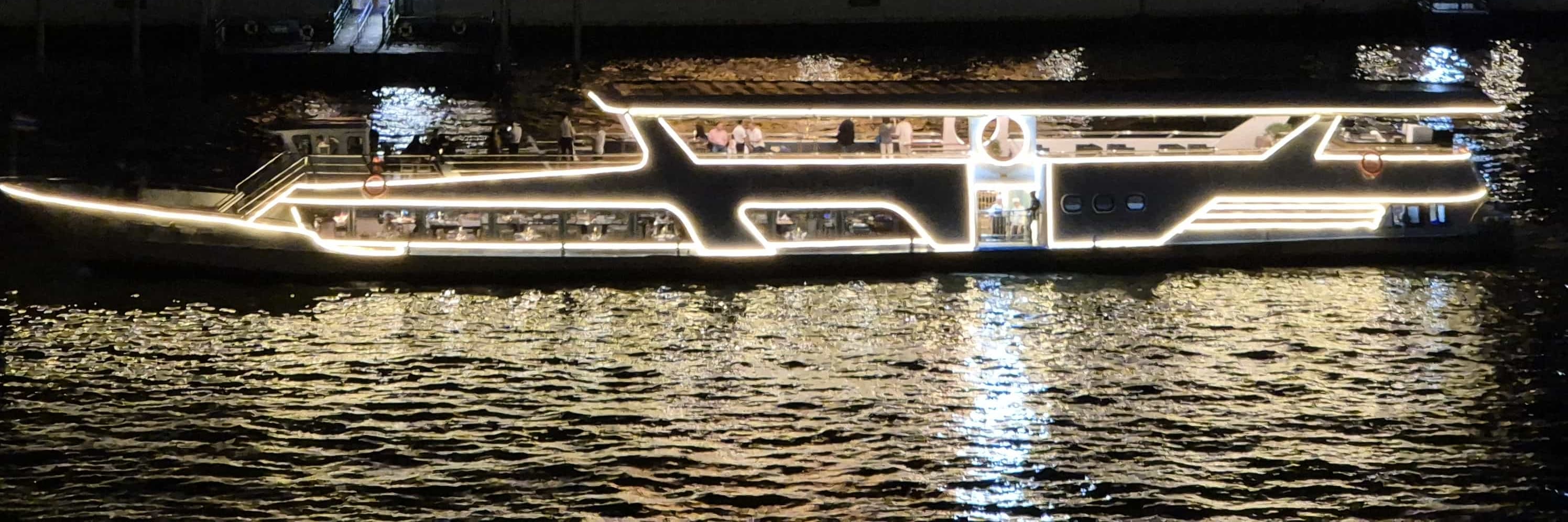 "Sailing past the glowing Wat Arun at night."
