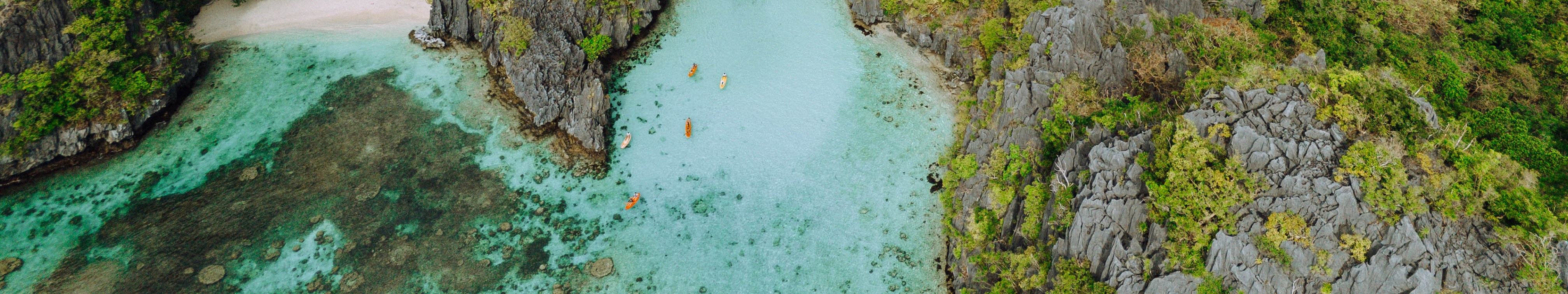 探索巴拉望愛妮島標誌性的大潟湖，這裡以其清澈見底的海水、高聳的石灰岩懸崖和令人難忘的獨木舟體驗而聞名。