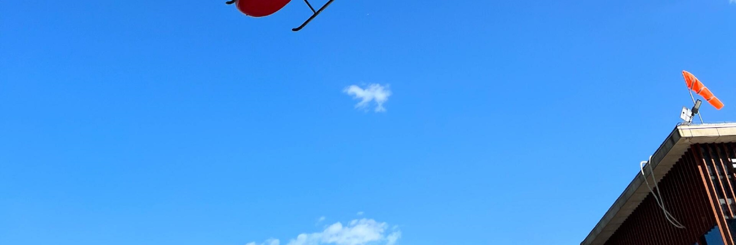 紅色直升機劃破澄澈藍天，在千島湖上空自在翱翔，鮮豔色彩與白雲相映，充滿動感與活力，盡顯空中飛行的自由與熱烈