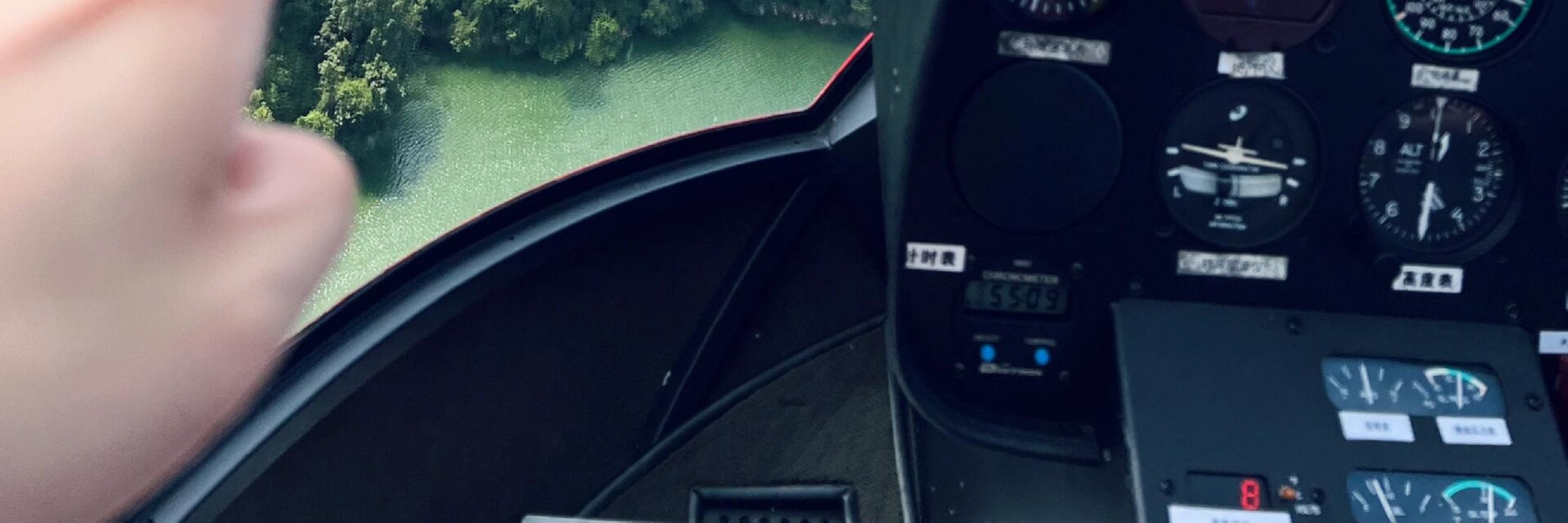 駕駛艙內，指尖輕指窗外千島湖山，澄澈湖水環繞青山，高空視角下的山水肌理清晰可見，沉浸式解鎖高空視野的治癒與震撼