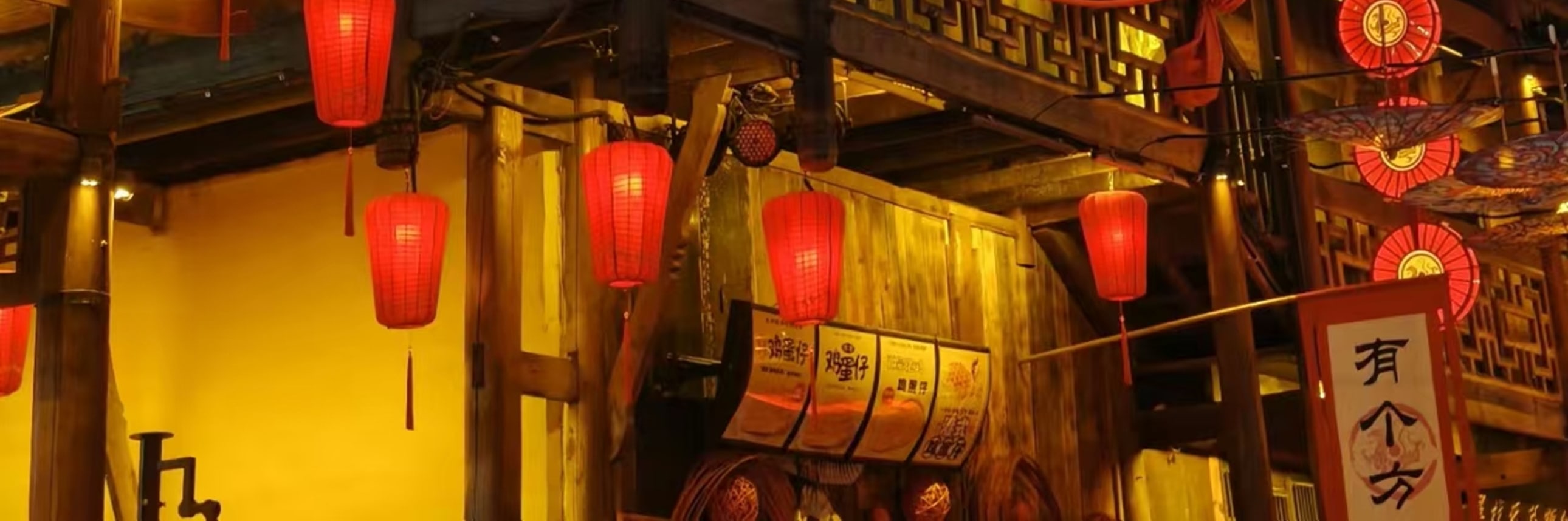 暮色漸濃時，這座三層木樓被紅燈籠與暖黃燈光點亮，層層疊疊的雕花欄杆與木樑在夜色裡格外醒目