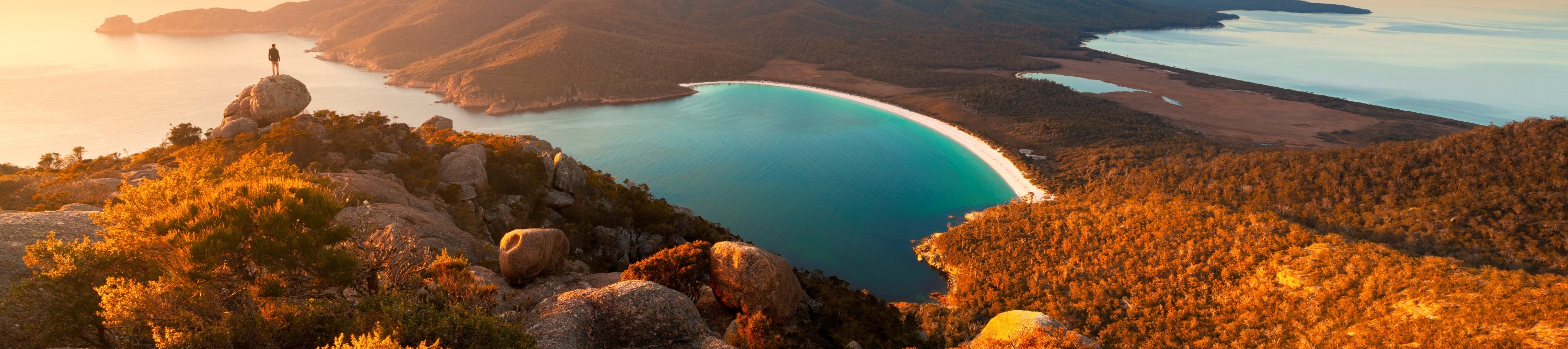 Wineglass Bay is a world-renowned beach located within Freycinet National Park on the east coast of Tasmania. Known for its stunning crescent-shaped shoreline, crystal-clear turquoise waters, and pristine white sand.