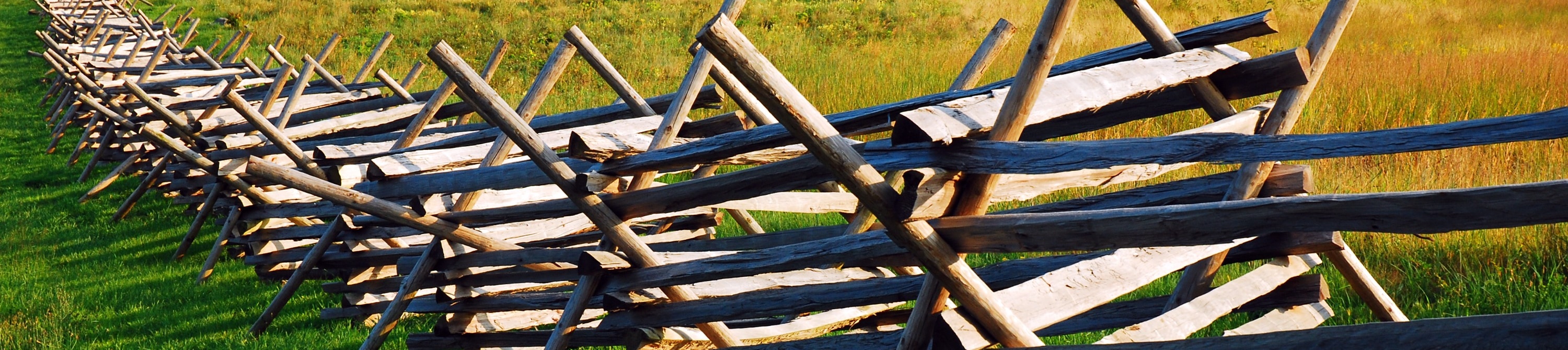 Observe a wood split rail fence cutting through a field at Gettysburg National Battlefield