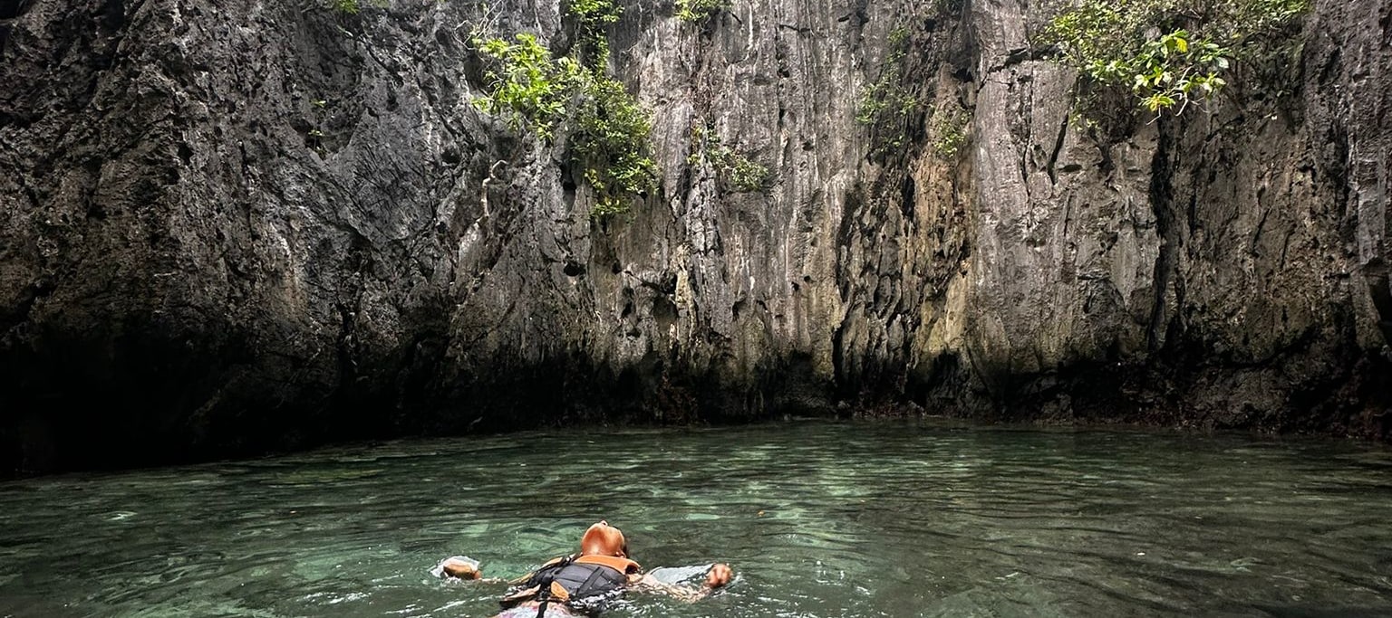 在愛妮島清澈見底的海水中漂浮，四周環繞著高聳的石灰岩懸崖和茂盛的綠色植物，享受寧靜的時刻。