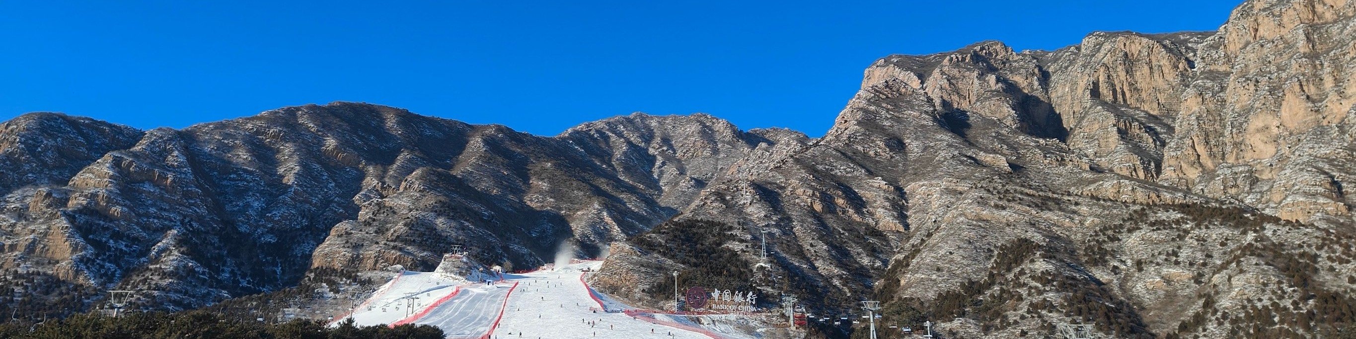 石京龍滑雪場地處北京延慶區，緊鄰龍慶峽景區，從市區駕車約 2 小時可達，坐擁山野自然風光，兼具交通便利性與生態景觀優勢。​您的專屬司機會從您的飯店全程接送，抵達後在停車場等候返程，無需費心交通銜接。您可自由進入雪場暢玩，滑雪時能盡覽周邊山巒雪景，沉浸式感受 “冰雪 + 山野” 的清新愜意。​
作為冬季熱門冰雪目的地，這裡場地開闊、雪道豐富：有適合初學者的初級練習道，也有滿足進階需求的中高級雪道，還配備齊全的雪具租賃區與專業教練團隊，無論有無滑雪基礎，都能獲得適配的遊玩服務。