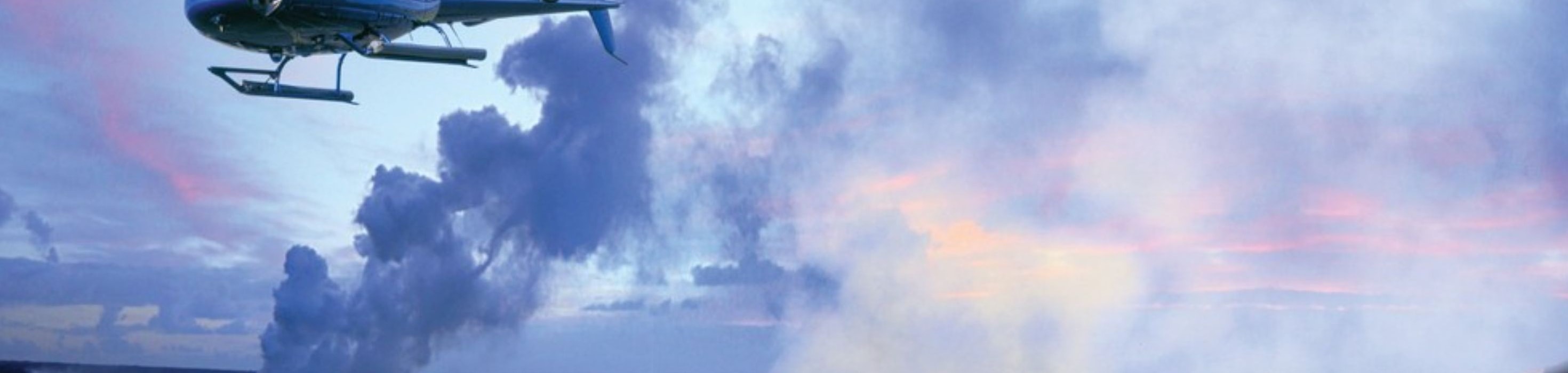 Helicopter soars near the volcano, offering breathtaking aerial views of the rugged landscape